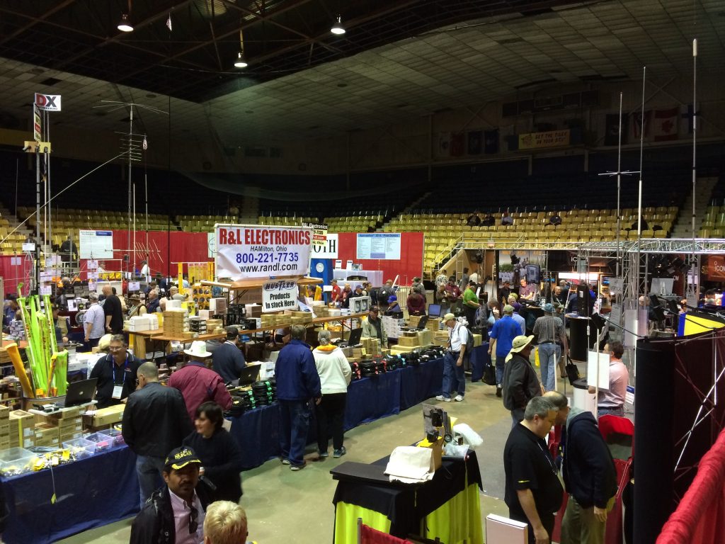 Dayton Hamvention show floor with vendors displaying ham radio equipment and participants exploring gear and treasures.